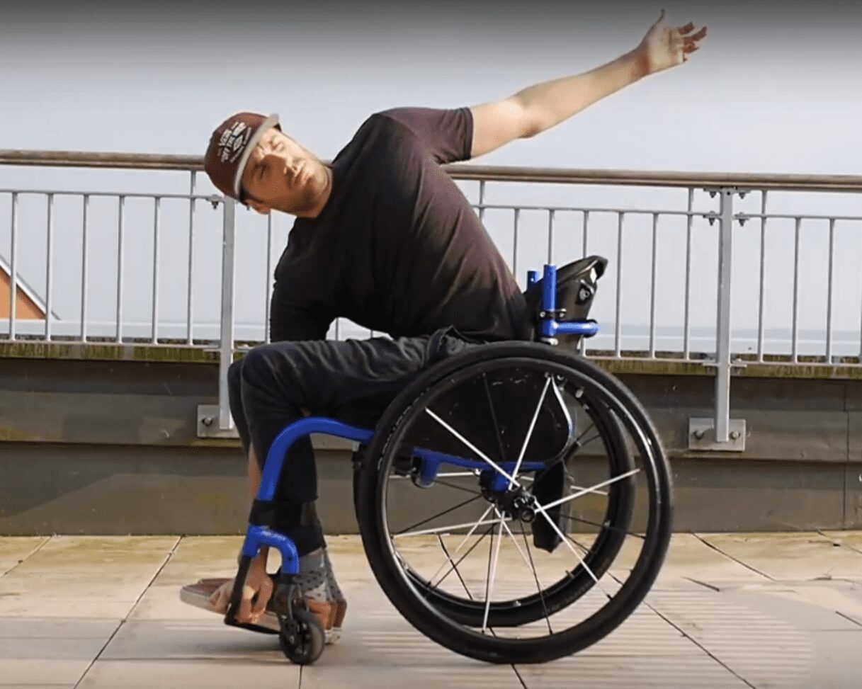 Man in wheelchair reaching for his feet