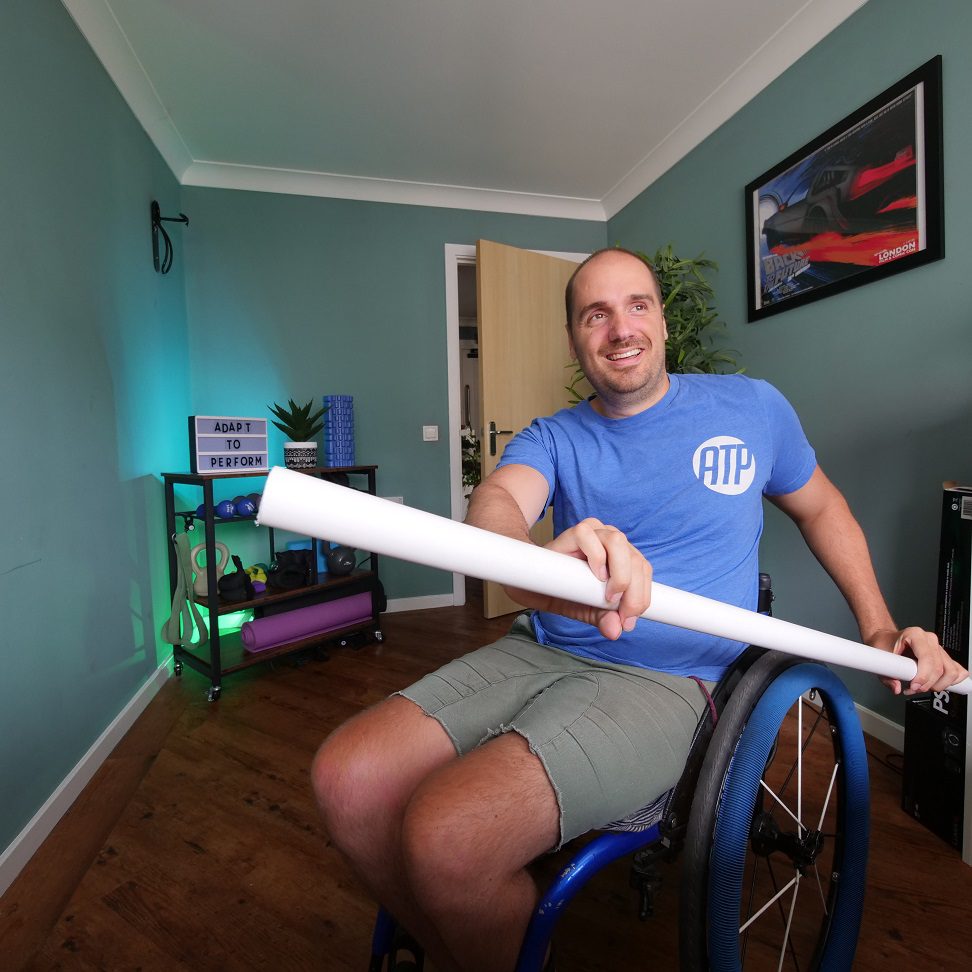 Man in Wheelchair at home stretching out with pole