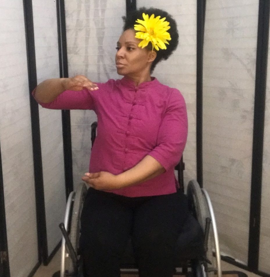 Woman practicing Qigong movements in wheelchair
