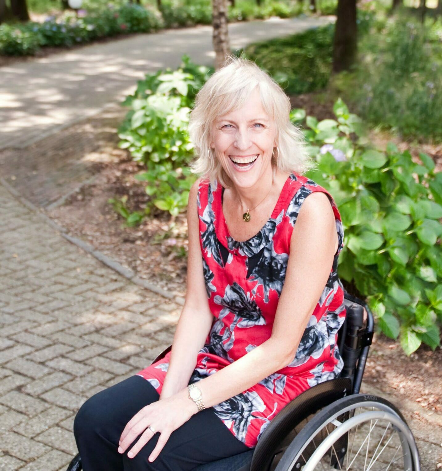 vidyamala laughing photoshopped Smiling blonde woman sitting in a manual wheelchair looks straight at the camera