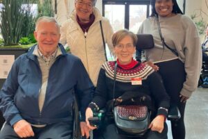 Group of four smiling Holiday Hangout attendees, including Elizabeth Fust